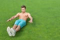 Young man doing sit-ups on sports field Royalty Free Stock Photo