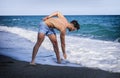 Young man doing stretching exercise on beach Royalty Free Stock Photo