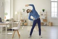 Young man doing stretching exercise while having fitness workout at work or at home Royalty Free Stock Photo