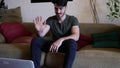 Young man doing videochat at home on laptop PC