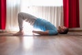 Young man doing wheel pose in the living room practicing yoga Royalty Free Stock Photo