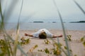 Young man doing yoga on a lake on a summer day, meditation, relaxation pose Royalty Free Stock Photo