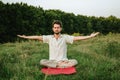 a young man doing yoga in nature, sitting in the lotus position 1 Royalty Free Stock Photo