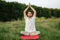 a young man doing yoga in nature with a smile, sitting in the lotus position 3 Royalty Free Stock Photo