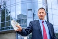 Young man with dollar banknotes standing near business center Royalty Free Stock Photo