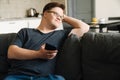 Young man with down syndrome using cellphone while sitting on couch Royalty Free Stock Photo
