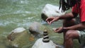 A Young Man With Dreadlocks Try to Stabilize Stack of Stones