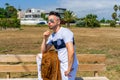 Young man dressed in white clothing and modern styling posing sitting on a wooden bench Royalty Free Stock Photo