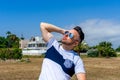 Young man dressed in white clothing and modern styling posing sitting on a wooden bench Royalty Free Stock Photo