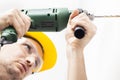 Young man drilling hole in wall Royalty Free Stock Photo