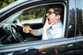 Young man drink coffee feeling tired and yawning while driving a car Royalty Free Stock Photo