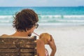 Young man drinking coconut milk on Chaise-longue on beach. Royalty Free Stock Photo