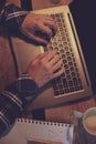 Young man drinking coffee in cafe and using laptop. Man`s hands Royalty Free Stock Photo