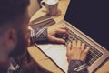 Young man drinking coffee in cafe and using laptop. Man`s hands Royalty Free Stock Photo