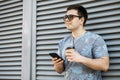 Young man drinking coffee in the city and looking into a mobile phone Royalty Free Stock Photo