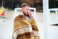 A young man drinking coffee with cup standing on the autumn beac Royalty Free Stock Photo