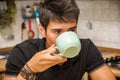 Young Man Drinking Coffee Sitting at Kitchen Table Royalty Free Stock Photo