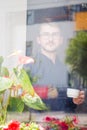 Young man drinking his morning coffee. Photo behind glass Royalty Free Stock Photo