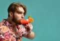 Young man drinking margarita cocktail drink juice happy looking at corner laughing over light blue mint Royalty Free Stock Photo