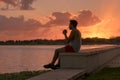 Young man drinking mate, traditional infusion of Latin America mainly in Argentina and Uruguay, by the lake enjoying and relaxing