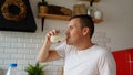 Young man drinking milk in kitchen. Adult male enjoying useful drink for breakfast. Royalty Free Stock Photo