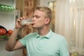 Young man drinking milk in the kitchen, standing at the fridge Royalty Free Stock Photo