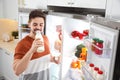 Man drinking milk near open refrigerator in kitchen Royalty Free Stock Photo