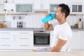 Young man drinking protein shake in kitchen Royalty Free Stock Photo