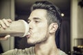 Young man drinking a smoothie drink or a protein shake