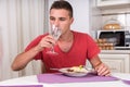 Young Man Drinking Water with Dinner Royalty Free Stock Photo