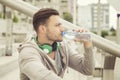 Young man drinking water and resting in between workouts Royalty Free Stock Photo