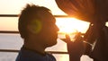 Young man is drinking white wine from a glass in a cafe at sunset near the sea. Royalty Free Stock Photo