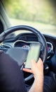 Young man driver using mobile phone in car, hand holding smart phone and driving and texting, transport business concept Royalty Free Stock Photo