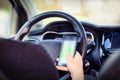 Young man driver using mobile phone in car, hand holding smart phone and driving and texting, transport business concept Royalty Free Stock Photo