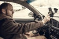 Young man driver using smartphone in car