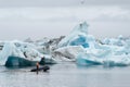 A young man drives a boat on an iceberg lake at the jokulsarlon lagoon in the vatnajokull national park