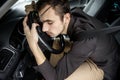 Young man is driving asleep. He is sitting at his car, his hands and head are on the steering wheel. Road safety concept Royalty Free Stock Photo