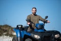 Young man driving a blue off-road quad bike in a rural area in daylight Royalty Free Stock Photo