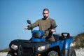 Young man driving a blue off-road quad bike in a rural area in daylight Royalty Free Stock Photo