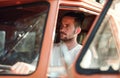 A young man driving a car on a roadtrip through countryside. Royalty Free Stock Photo