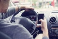 Young man driving car and using mobile phone Royalty Free Stock Photo