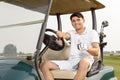 Young man driving cart on a golf course Royalty Free Stock Photo