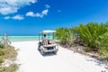 Young man driving on a golf cart at tropical white sandy beach Royalty Free Stock Photo