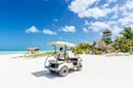 Young man driving on a golf cart at tropical white sandy beach Royalty Free Stock Photo