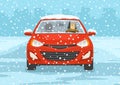 Young man driving a red mini car on a snowy city road. Front view. Royalty Free Stock Photo