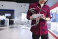 Young man in a drones store. Quadcopter in the hands. A young man buys a drone in a tech store