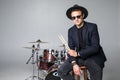 Young man drummer behind drum set and plays the drums in studio background Royalty Free Stock Photo