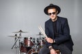 Young man drummer behind drum set and plays the drums in studio background Royalty Free Stock Photo