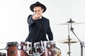 Young man drummer behind drum set and plays the drums in studio background Royalty Free Stock Photo