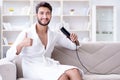 The young man drying hair at home with a hair dryer blower Royalty Free Stock Photo